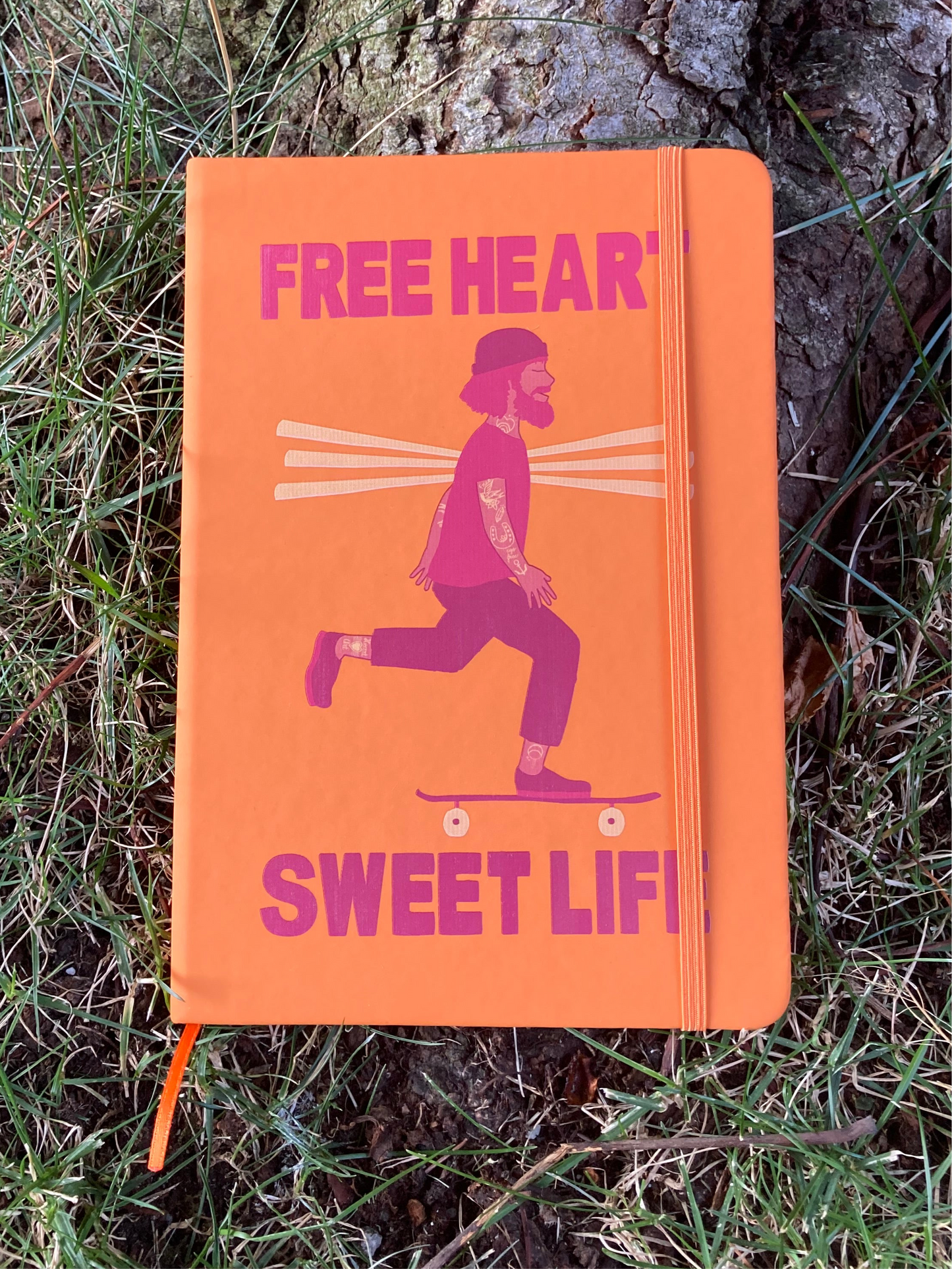 Cuaderno con goma naranja.